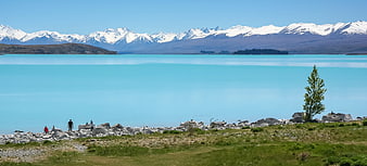 Turquoise Lake with Snow-Capped Mountains and Hikers