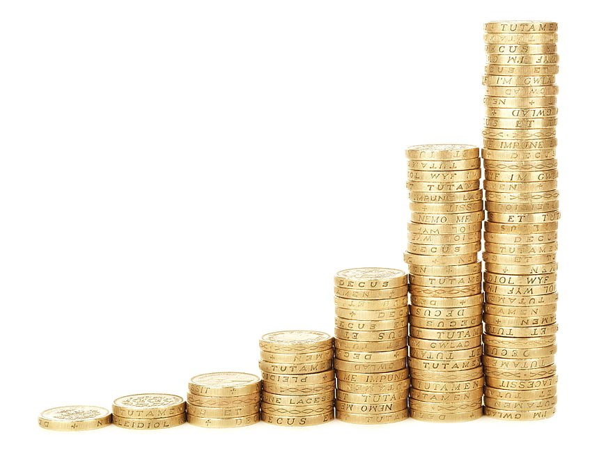 Stacks of gold coins forming a growth chart on white background