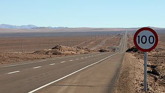 Speed Limit 100 Sign On Empty Highway In Chilean Desert