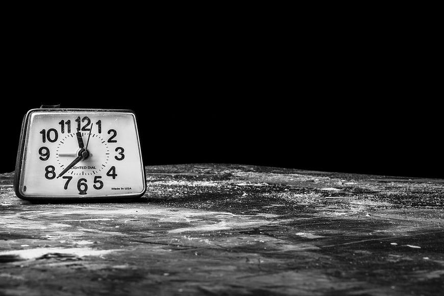 Vintage black and white alarm clock on textured surface