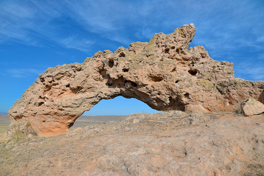 Natural sandstone rock arch formation against blue sky