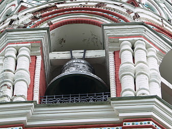 Close-up of ornate church bell tower with red brick and white columns