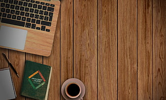 Flat lay of laptop, coding book, and coffee on wooden desk