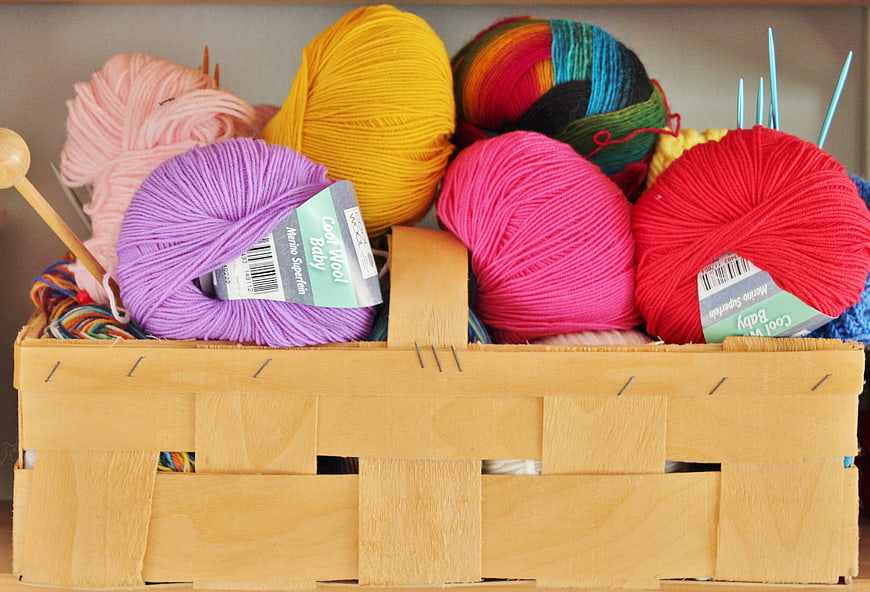 Colorful yarn balls in a wooden knitting basket
