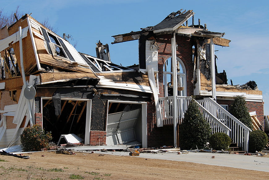 Severely damaged house with collapsed roof and exposed interior