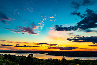 Vibrant Sunset Over Lake and Forest Landscape