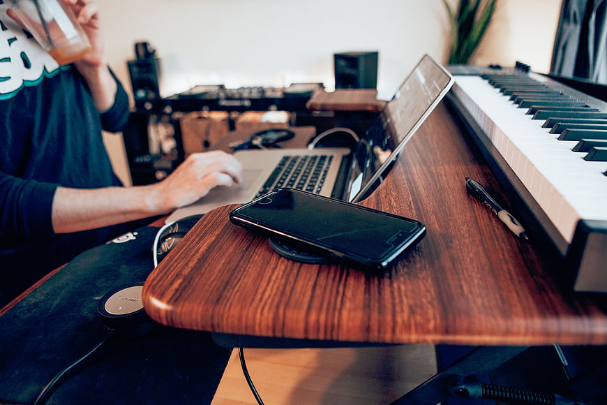 Music Producer Working at Home Studio Desk with Laptop and Keyboard