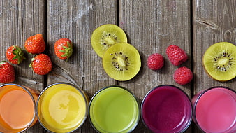 Colorful fruit smoothies and fresh berries on rustic wooden table