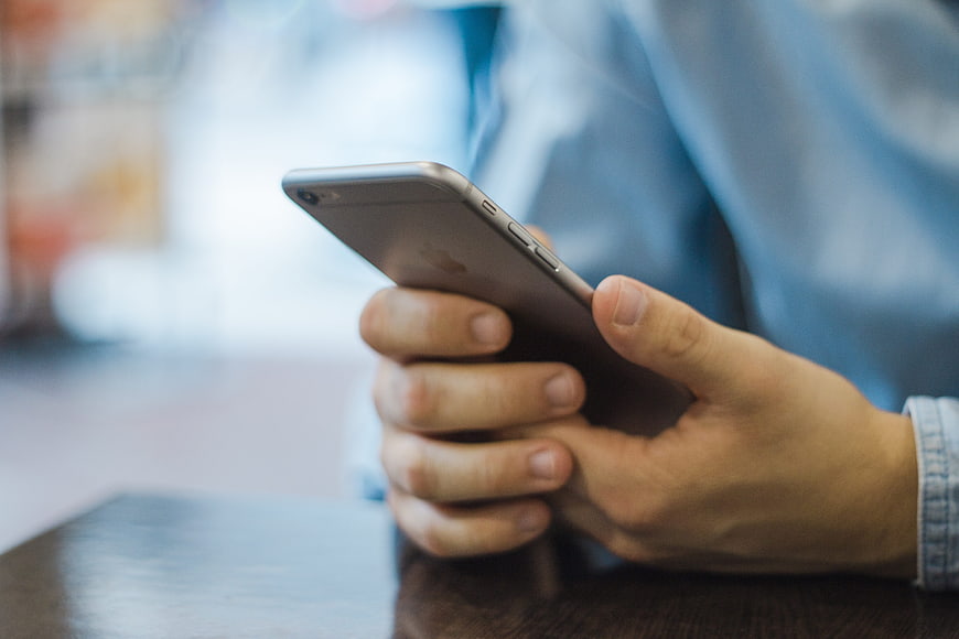 Close-up of hands holding a silver smartphone
