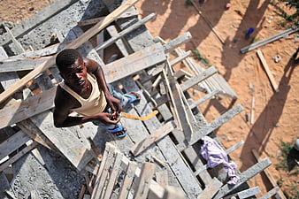 High angle view of construction worker on wooden scaffolding