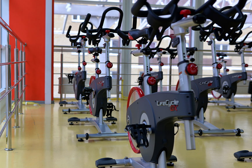 Rows of stationary exercise bikes in a modern gym studio