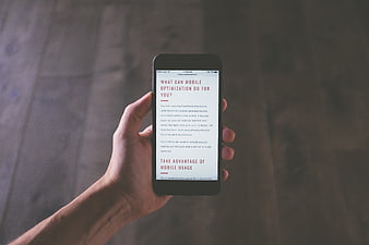 Hand holding smartphone displaying mobile optimization article