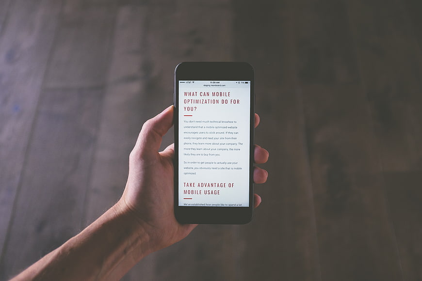 Hand holding smartphone displaying mobile optimization article