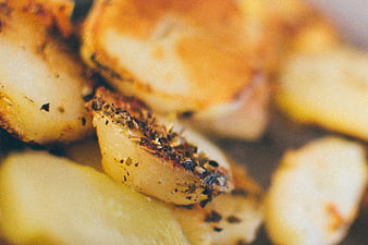 Close-up of roasted potato wedges with herbs and spices