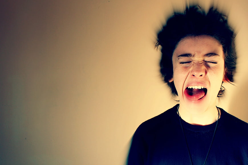 Young woman screaming in anger with motion blur effect