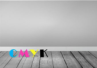 3D CMYK letters on gray wooden floor against white wall