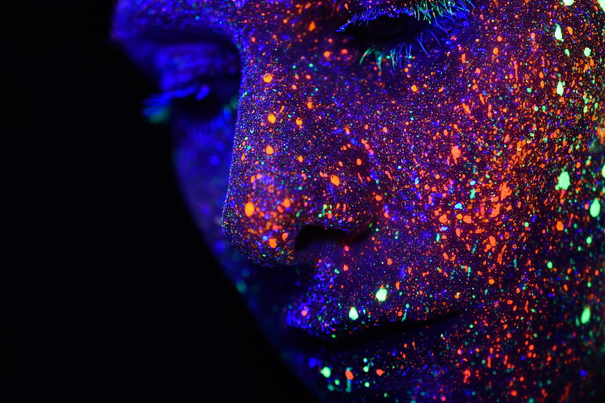 Close-up of face with glowing neon UV paint