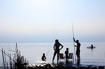 Silhouette of Family Fishing at Calm Sea Shore