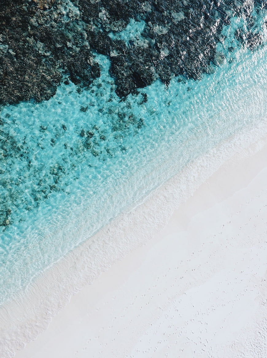 Aerial View of Turquoise Ocean Waves Crashing on White Sandy Beach