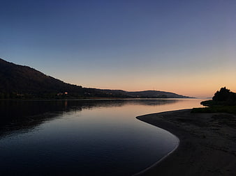Serene River Landscape at Dusk with Sandy Shore