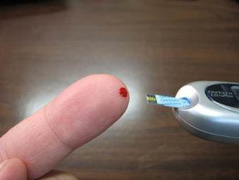 Close-up of finger prick blood test for diabetes monitoring
