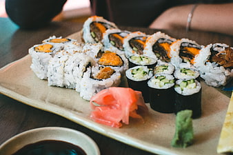 Assorted sushi rolls with ginger and wasabi on ceramic plate