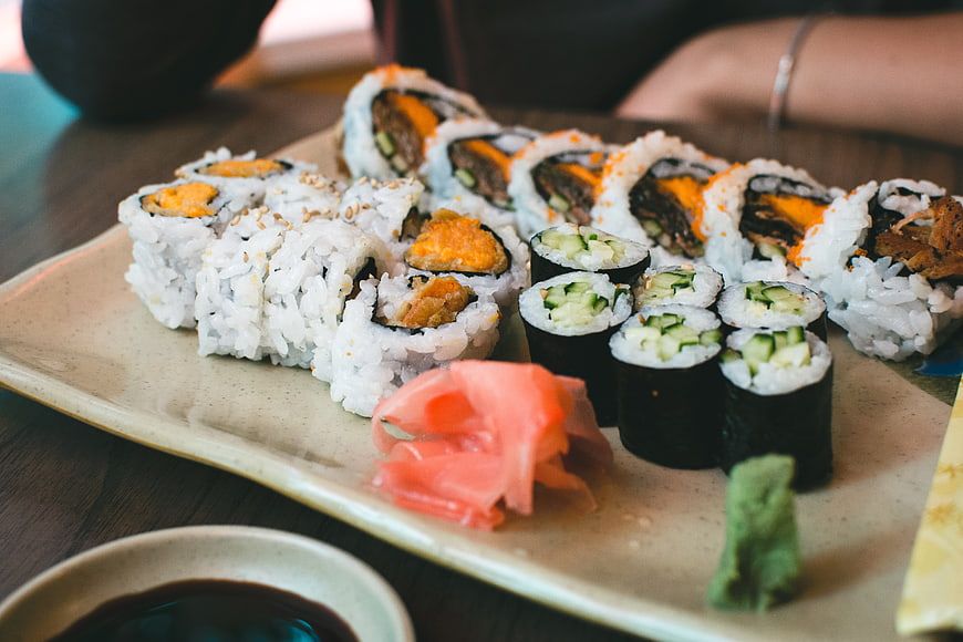 Assorted sushi rolls with ginger and wasabi on ceramic plate