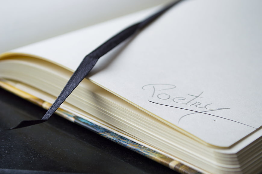 Open Notebook with Handwritten Poetry Title and Ribbon Bookmark