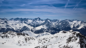 Panoramic View of Snow-Covered Mountain Range Under Blue Sky