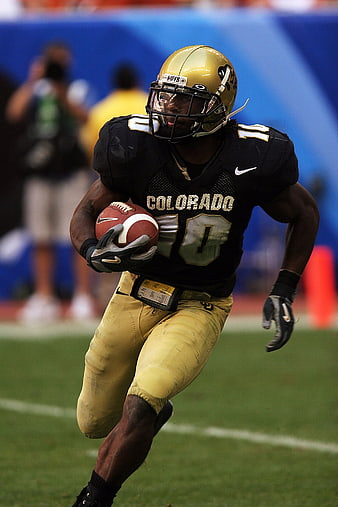 American Football Player Running with Ball in Black and Gold Uniform