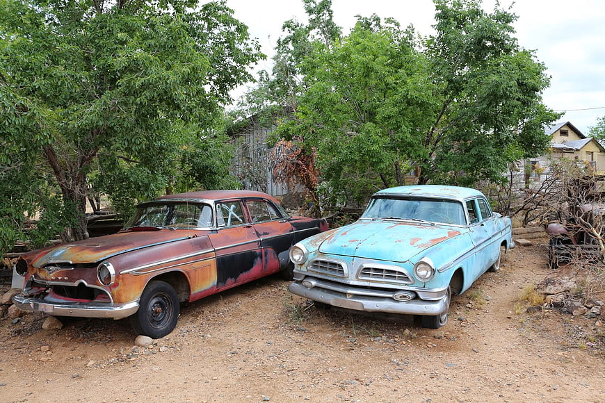 Two vintage American cars in a junkyard