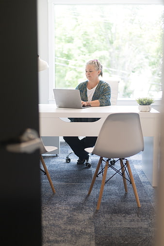 Woman working on laptop in bright modern office
