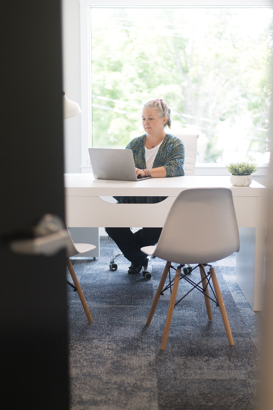 Woman working on laptop in bright modern office