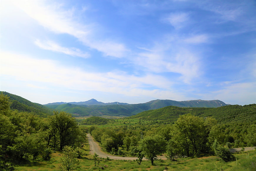 Winding Road Through Green Valley and Mountains