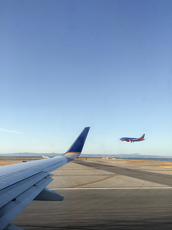 Airplane Wing View with Takeoff on Airport Runway