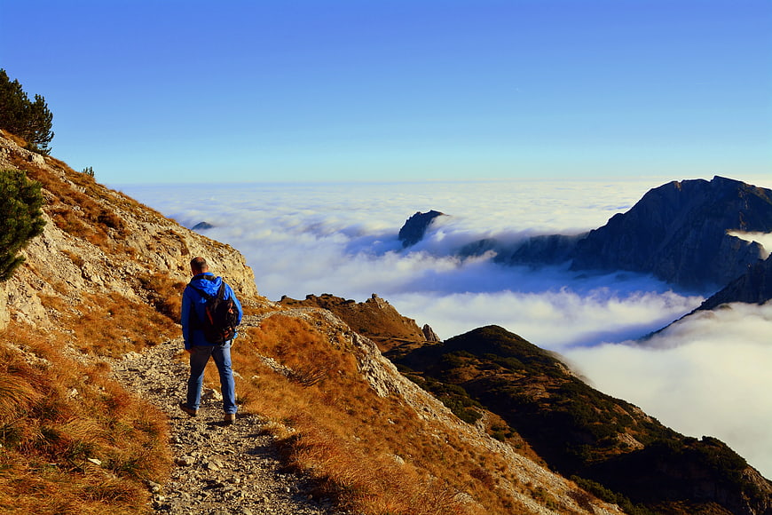 Hiker on Mountain Trail Above Sea of Clouds