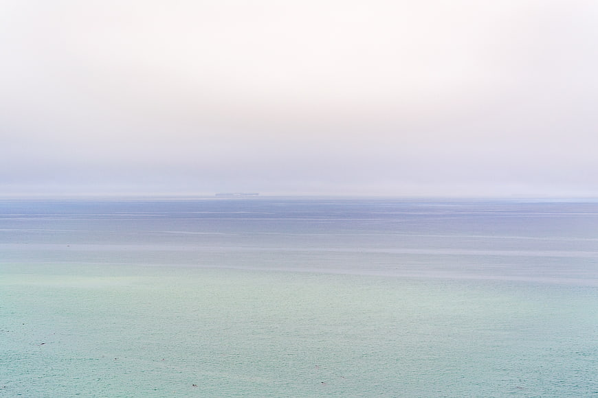 Serene Misty Ocean Horizon with Distant Ship
