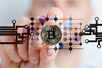 Hand holding Bitcoin coin with digital circuit board overlay