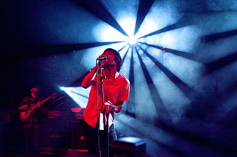 Male Singer Performing on Stage with Dramatic Blue Spotlight