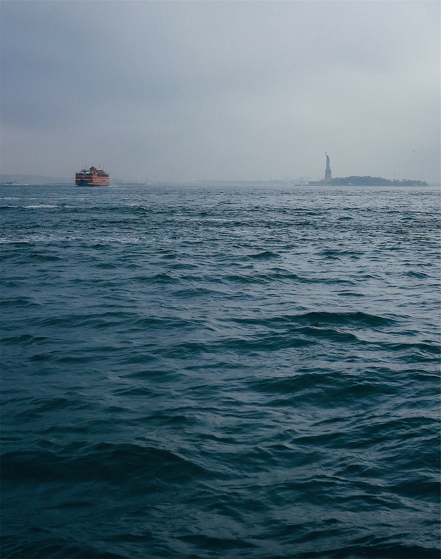 Statue of Liberty and Ferry in Hazy New York Harbor