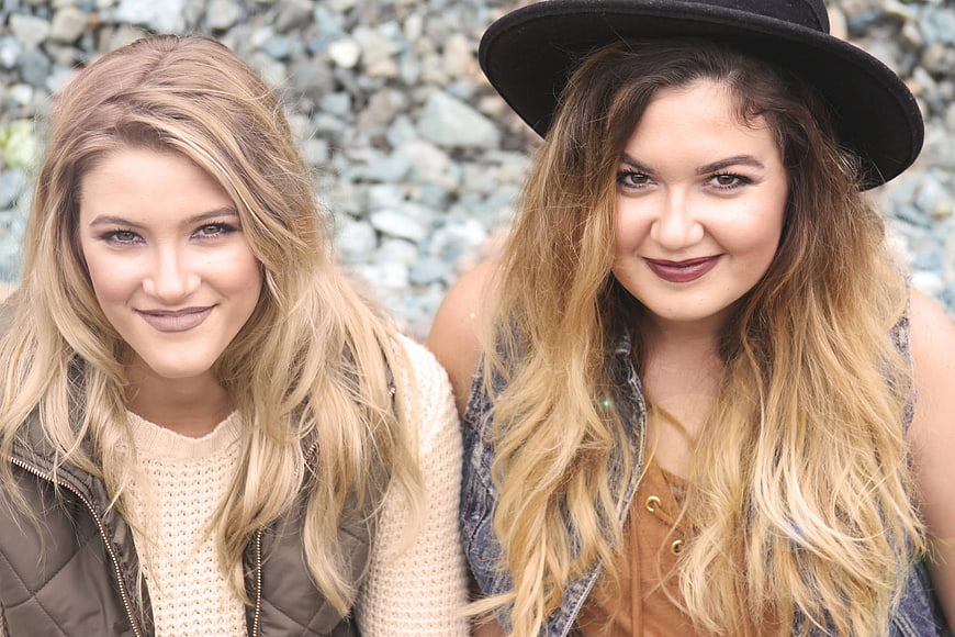 Portrait of two smiling young women with blonde hair outdoors