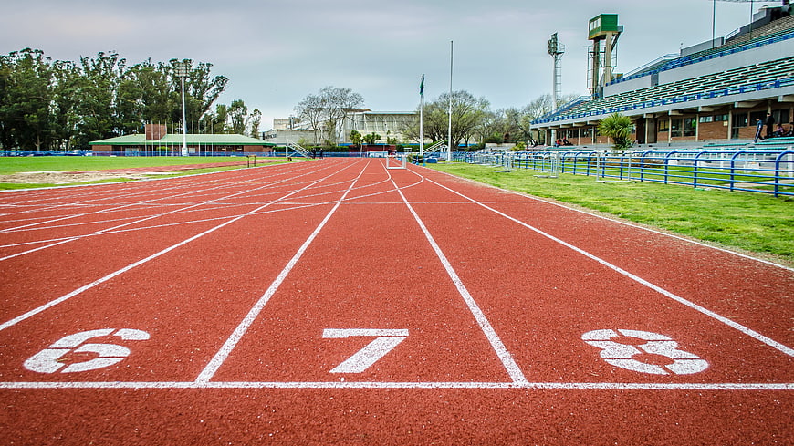 Empty Red Running Track with White Lane Numbers