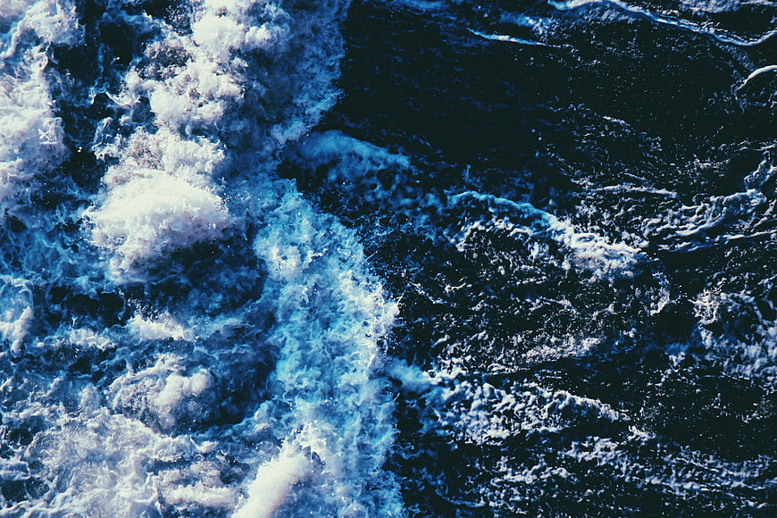 Aerial View of Turbulent Blue Ocean Waves and White Sea Foam