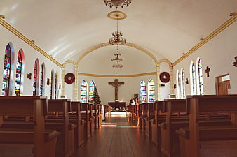 Interior of a historic church with wooden pews and stained glass windows