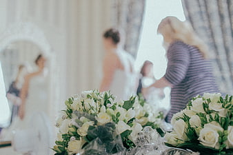 White Wedding Bouquets with Blurred Bride Preparing in Background