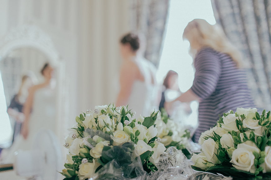 White Wedding Bouquets with Blurred Bride Preparing in Background
