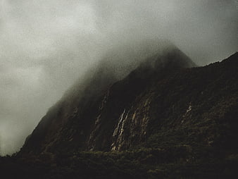 Misty Mountain Peak with Waterfall in Foggy Forest