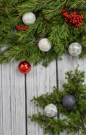 Christmas pine branches and ornaments on white wood background