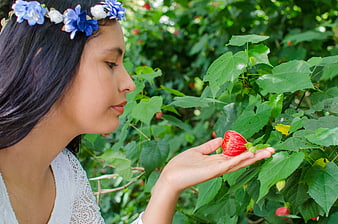 Young Woman with Flower Crown Smelling Red Hibiscus Bud