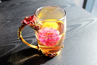 Glass Mug With Blooming Chrysanthemum And Rose Tea On Dark Table